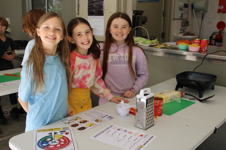 three students cooking