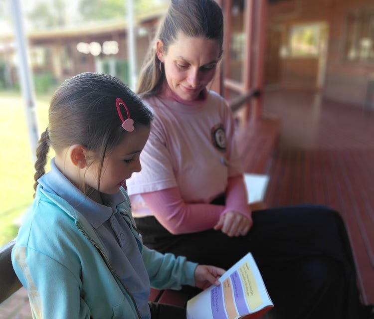 Student reading to teacher